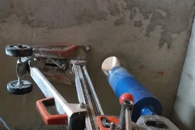 Equipamento de perfuração diamantada posicionado para furo em piso de concreto